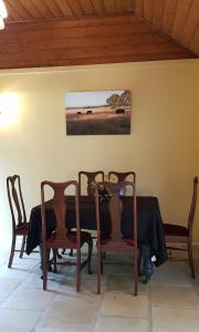 mesa de comedor con sillas y una foto en la pared en Olinda Yarra Cottage, en Yering