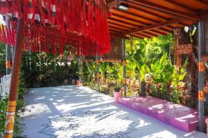 a covered walkway with red fabric and plants at Villa Dua in Nusa Dua
