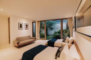 a bedroom with two beds and a couch and a window at LeBAOH VILLA - Lembongan island in Nusa Lembongan +47 photos