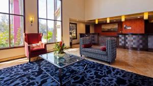 a lobby with a table and two chairs and a bar at Best Western Plus Newport Mesa Inn in Costa Mesa