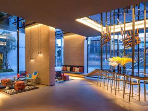 a lobby with a table and chairs in a building at ibis Styles Bangkok Sukhumvit Phra Khanong in Bangkok +102 photos