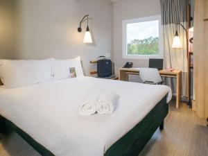 Una habitación de hotel con una cama con toallas. en ibis Itatiba, en Itatiba