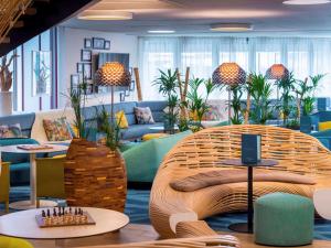 a lobby with a couch and tables and chairs at Mercure Toulouse Centre Saint-Georges in Toulouse
