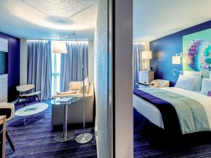 a hotel room with a king sized bed and a chair at Mercure Toulouse Centre Saint-Georges in Toulouse