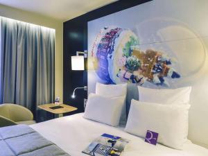 a hotel room with a bed with white pillows at Mercure Toulouse Centre Saint-Georges in Toulouse