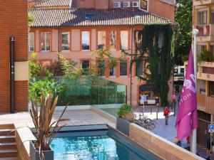 a swimming pool in the middle of a city at Mercure Toulouse Centre Saint-Georges in Toulouse