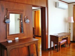 a room with a vanity and a mirror and a desk at Chiang Mai Phucome Hotel in Chiang Mai