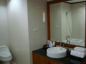 a bathroom with a sink and a toilet and a mirror at Chiang Mai Phucome Hotel in Chiang Mai