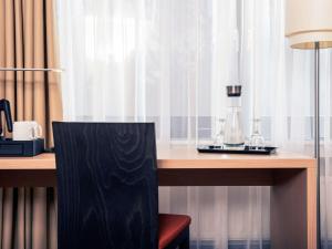 a desk with a table with a blender on it at Mercure Hotel Düsseldorf Neuss in Neuss