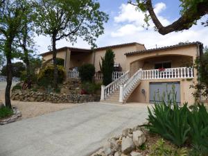 ein Haus mit einem weißen Zaun und einer Auffahrt in der Unterkunft Gîtes de l'Esquirou in Lagorce