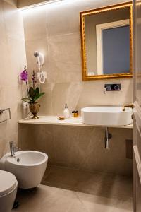 a bathroom with a sink and a toilet and a mirror at B&B Palazzo Cerami in Catania