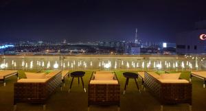 a rooftop patio with tables and chairs at night at Shilla Stay Samsung COEX Center in Seoul