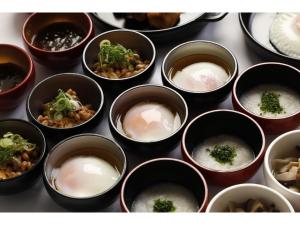 un groupe de bols remplis de riz et de brocolis dans l'établissement Dormy Inn Premium Hakata Canal City Mae, à Fukuoka