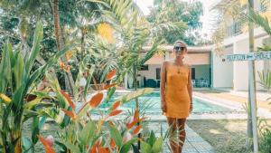a woman in an orange dress standing next to a street sign at Green Hill Mirissa in Mirissa