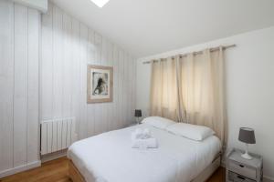 a bedroom with a white bed with a stuffed animal on it at Villa Emeraude by Cocoonr in Saint-Briac-sur-Mer