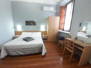 Schlafzimmer mit einem Bett, einem Schreibtisch und einem Schreibtisch in der Unterkunft Albergo in Centro in Turin
