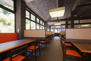 a dining room with tables and chairs and windows at Susukinohara Ichinoyu in Hakone