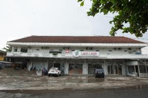 un edificio con dos coches estacionados frente a él en SUPER OYO 850 Lapan Lapan en Banjarmasin