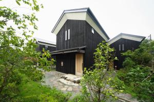 een zwart huis met een gambrel dak bij Sengokuhara Shinanoki Ichinoyu in Hakone