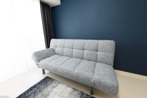 a gray couch in a room with a blue wall at Cocostay KO Residence Sennichimae#603ココステイ ケーオーレジデンス センニチマエ#603 in Okayama