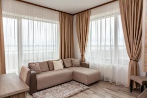 a living room with a couch in front of windows at Summerland Sea View Apartment in Mamaia