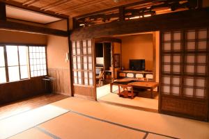 una sala de estar con una habitación con una mesa y una habitación con una habitación en Yunoyado Irifune, en Aso