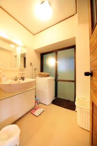 a bathroom with a sink and a mirror at Exsaison house Kumoji in Naha