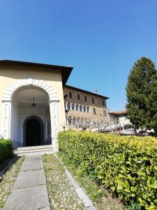 ein Gebäude mit einem Torbogen neben einer Hecke in der Unterkunft Residenza Santa Valeria in Caglio
