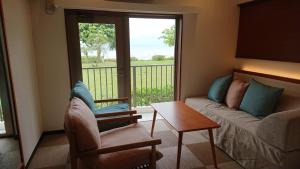 
a living room filled with furniture and a window at Ishigaki Seaside Hotel in Ishigaki Island
