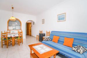 een woonkamer met een blauwe bank en een tafel bij Bungalows Canadá Alquileres Vacacionales in Calpe