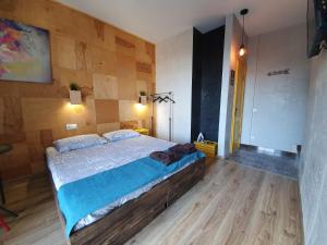 ein Schlafzimmer mit einem großen Bett und einer Holzwand in der Unterkunft Посуточно апартаменты Ивано-Франковск 602 in Iwano-Frankiwsk
