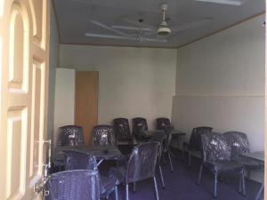 a room with rows of chairs and tables with purple chairs at River Breeze Guest House 
