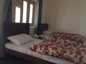 een slaapkamer met een bed met een bloemendeken bij River Breeze Guest House 