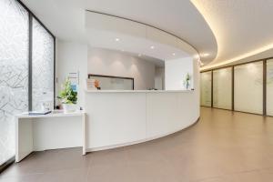 an empty lobby with white walls and a large window at All Suites Appart Hôtel Bordeaux Pessac in Pessac