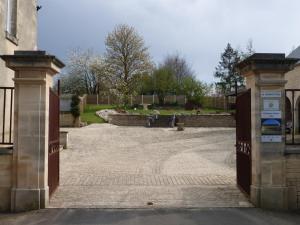 an entrance to a house with a gate to a courtyard at Gite LA CHARRETTERIE in Martragny