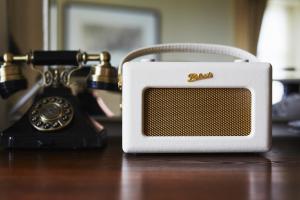 a white radio sitting on a table next to a phone at The Roseate Edinburgh - Small Luxury Hotels of the World in Edinburgh