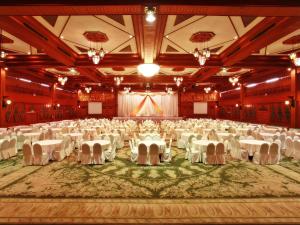 een grote feestzaal met witte tafels en stoelen bij Chiang Mai Phucome Hotel in Chiang Mai