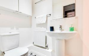 a white bathroom with a sink and a toilet at 3 Bedroom Townhouse near South Park Oxford - close to city centre ! in Oxford