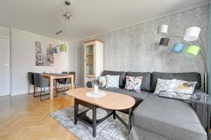 a living room with a couch and a table at Wave Apartments - Grobla Old Town in Gdańsk