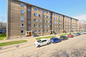 a row of cars parked in front of a building at Wave Apartments - Grobla Old Town in Gdańsk