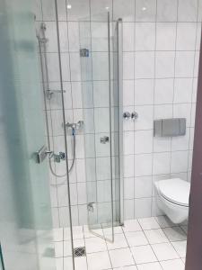 uma casa de banho com uma cabina de duche em vidro e um WC. em Hotel Bairischer Hof em Marktredwitz