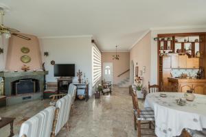 a living room with a table and chairs and a fireplace at villa nicol in Korinthos