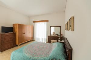 a bedroom with a bed and a dresser and a television at villa nicol in Korinthos