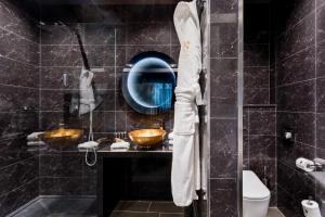 a bathroom with a sink and a mirror and a toilet at H Hotel & SPA - Adults Only in St. Julianʼs