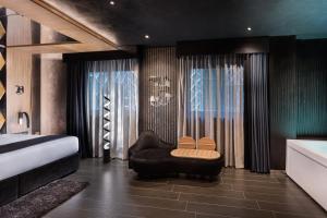 a bedroom with a couch and a chair and a bed at H Hotel & SPA - Adults Only in St. Julianʼs