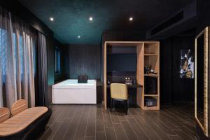 a living room with a couch and a table and a desk at H Hotel & SPA - Adults Only in St. Julianʼs