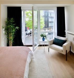 ein Schlafzimmer mit einem Bett, einem Stuhl und einem Fenster in der Unterkunft Splendid & cosy studio - perfect location 'Stephanie-Louise area' in Brüssel