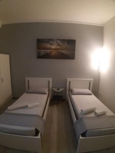 Una habitación con dos camas y una mesa dentro. en Affittacamere Romina, en Bolonia