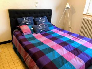 - un lit avec une couverture et des oreillers colorés dans l'établissement Studio 2 pers en vieille ville parking gratuit - by La Source d'OrFée, à Boulogne-sur-Mer
