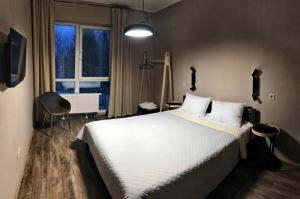 ein Schlafzimmer mit einem weißen Bett und einem Fenster in der Unterkunft Авиатик in Schytomyr